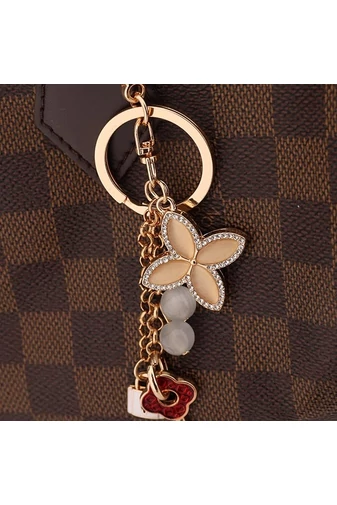  Elegancki, dwustronny brelok z kwiatkiem w kolorze białym z beżowymi dodatkami w kolorze złotym